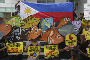 Protesters wearing fish-shaped hats gather outside the Chinese Consulate during a rally in suburban Makati, south of Manila, Philippines on Tuesday June 11, 2013. The group held the rally to oppose China's alleged continued intrusion and poaching activities in the West Philippine Sea. (AP Photo/Aaron Favila)