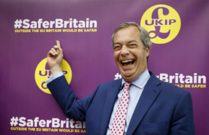 Nigel Farage, leader of Britain's UK Independence Party laughs as he points to a UKIP poster, before delivering a speech on the forthcoming EU referendum, in London, Friday, April 29, 2016. (AP Photo/Kirsty Wigglesworth)